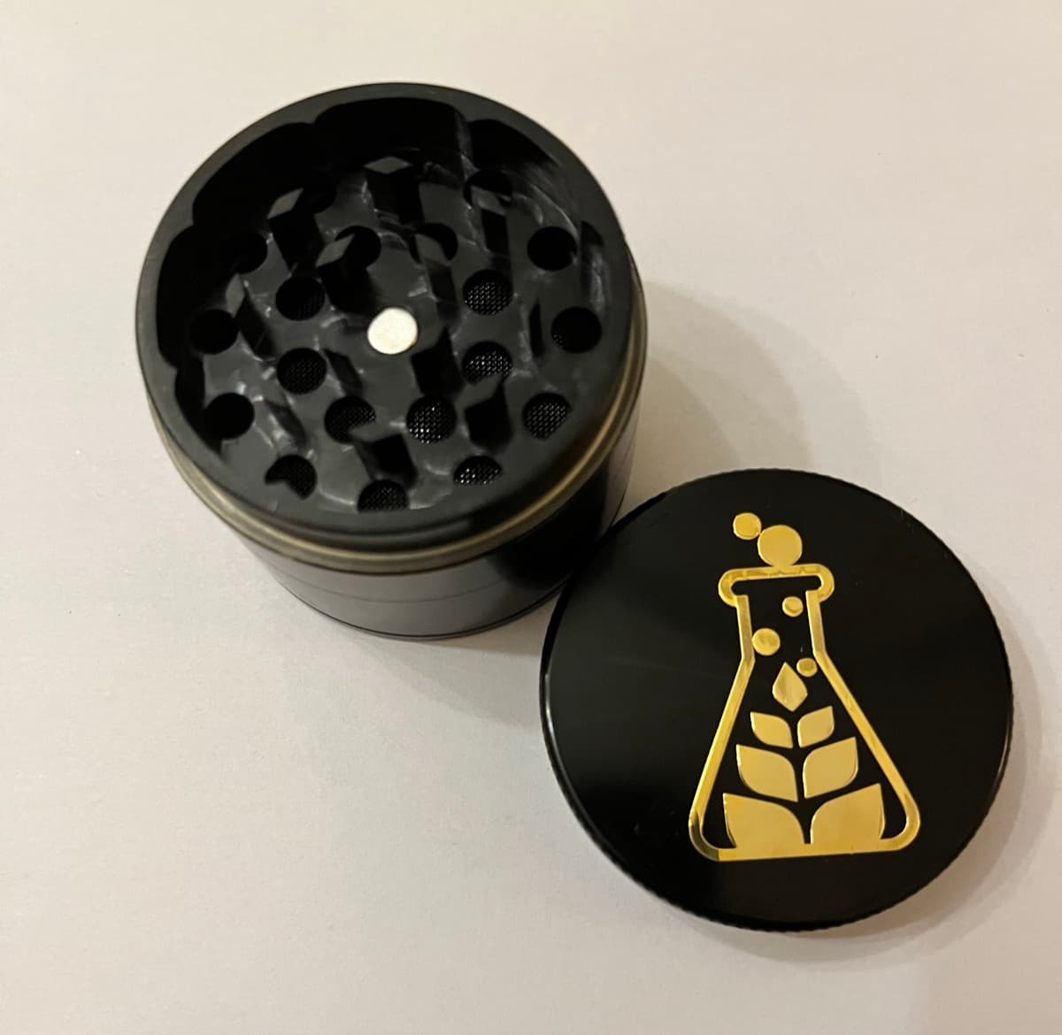 Custom grinder with gold engraved Sanctuary Medicinals logo